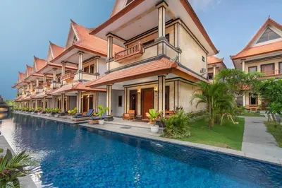 a villa with a swimming pool next to a house at The Salila Beach Resort in Seminyak