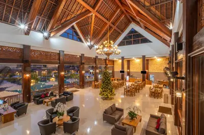 a lobby with a christmas tree in the center at The Salila Beach Resort in Seminyak