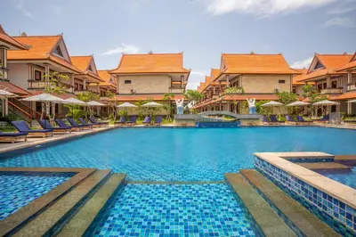 a swimming pool at a resort with chairs and umbrellas at The Salila Beach Resort in Seminyak