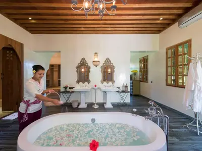 a woman standing in a bathroom with a tub at Sayang d'Amour in Seminyak