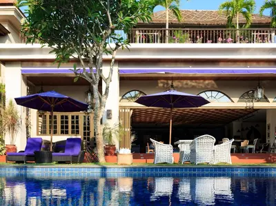 a group of chairs and umbrellas next to a swimming pool at Sayang d'Amour in Seminyak