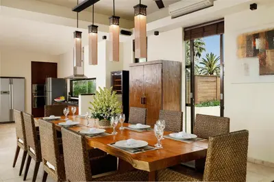 a dining room with a wooden table and chairs at Villa Jamalu by Nakula in Jimbaran