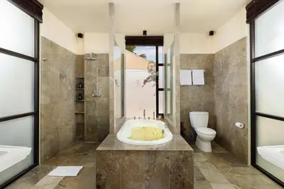 a bathroom with a tub and a sink and a toilet at Villa Jamalu by Nakula in Jimbaran