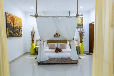 a bedroom with a bed with a canopy at MasBro ART Villas in Seminyak