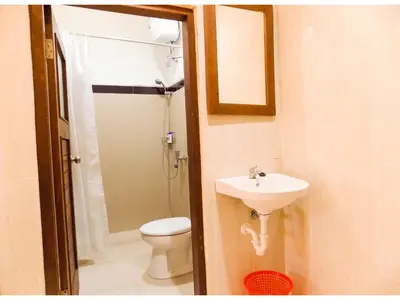 a bathroom with a sink and a toilet and a shower at Guna Graha Kuta by Kamara in Kuta