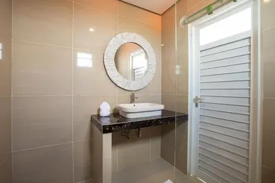 a bathroom with a sink and a mirror at Villa Ultima Umalas in Canggu
