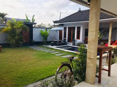 a bike parked in the yard of a house at Villa Pintu Biru in Seminyak