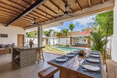 a dining room with a table and a pool at Villa Jamu in Seminyak