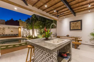an outdoor kitchen with a sink and a pool at Villa Jamu in Seminyak