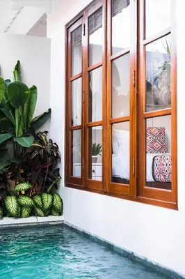 a house with a swimming pool and a window at Villa Karang in Seminyak