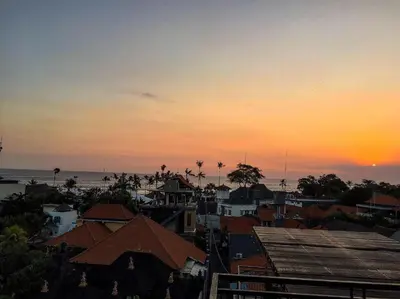 a view of a city with a sunset in the background at Dana Homestay in Canggu