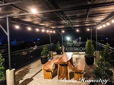 a table and chairs on a deck at night at Dana Homestay in Canggu