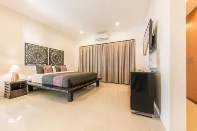 a bedroom with a bed and a television in it at Manis, Luxury 3 Bedroom Heart of Seminyak in Seminyak