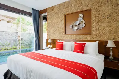 a bedroom with a large bed with red and white pillows at Del Cielo Villa Seminyak in Seminyak