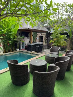 a group of wicker chairs sitting next to a swimming pool at D&D homestay in Pesanggaran