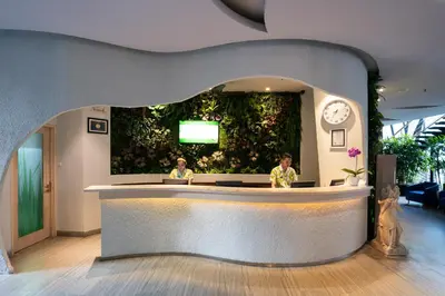 two women sitting at a reception desk in a lobby at EDEN Hotel Kuta Bali in Kuta