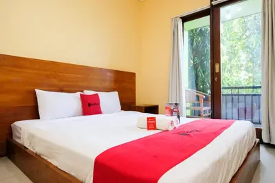 a bedroom with a large bed and a window at RedDoorz @ Kerta Dalem Sidakarya in Denpasar