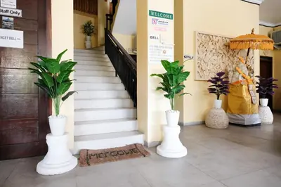 two white vases with plants in them in a hallway at RedDoorz @ Kerta Dalem Sidakarya in Denpasar
