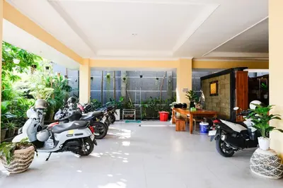 a group of motorcycles parked in a room with plants at RedDoorz @ Kerta Dalem Sidakarya in Denpasar