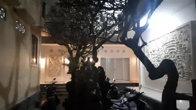 a group of people standing around a tree in a building at Adijaya homestay in Seminyak