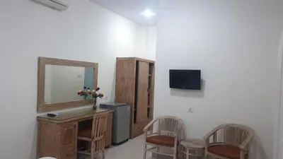 a room with a mirror and a vanity and chairs at Adijaya homestay in Seminyak
