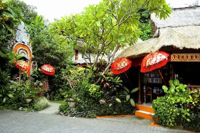 a building with red umbrellas in front of a store at Puri Cendana Resort Bali in Seminyak