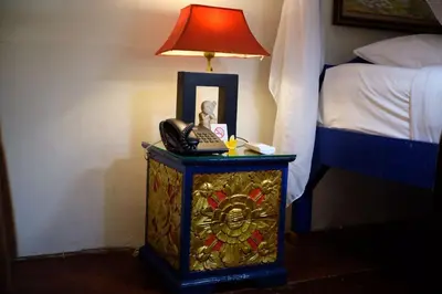 a lamp on a table next to a bed with a phone at Puri Cendana Resort Bali in Seminyak