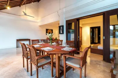a dining room with a wooden table and chairs at Villa Lalang Temu in Jimbaran