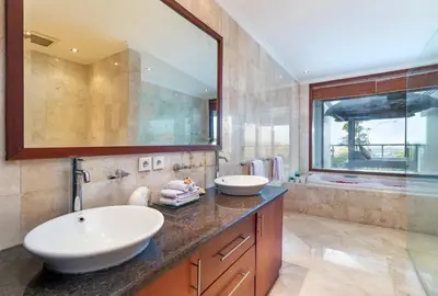 a bathroom with two sinks and a large mirror at Villa Lalang Temu in Jimbaran