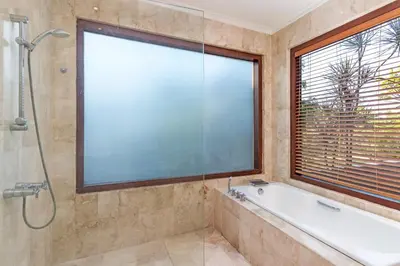 a bathroom with a tub and a large window at Villa Lalang Temu in Jimbaran