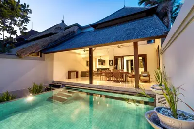 a villa with a swimming pool and a house at Villa Lalang Temu in Jimbaran
