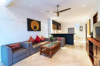 a living room with a couch and a table at Villa Lalang Temu in Jimbaran