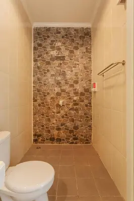 a bathroom with a toilet and a brick wall at Villa Julie & Villa Sydney, Seminyak - 2 Bedroom Modern Pool Villas! in Seminyak