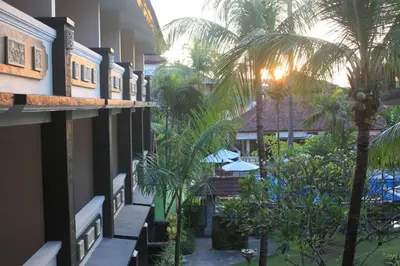 a view of the courtyard of a hotel with palm trees at Bakung Beach Resort in Kuta