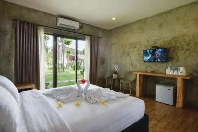 a bedroom with a white bed with a swan on it at Bali Breezz Hotel in Jimbaran