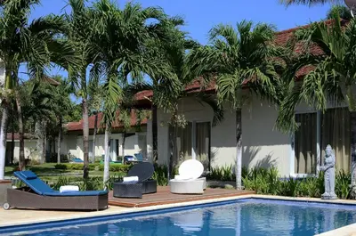 a resort with palm trees and a swimming pool at Bali Breezz Hotel in Jimbaran