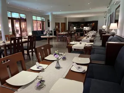a restaurant with wooden tables and chairs and tables and tablesearcher at Peninsula Beach Resort in Nusa Dua