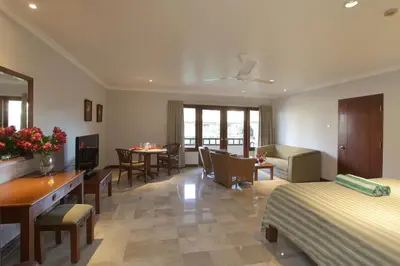 a hotel room with a bed and a dining room at Peninsula Beach Resort in Nusa Dua
