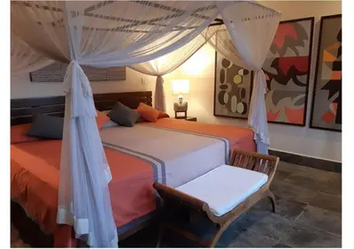 a bedroom with two beds and a chair at Villa Sukapadi in Seminyak