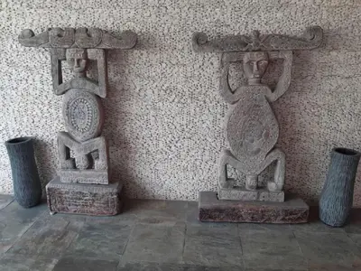 two stone statues sitting next to a wall at Villa Sukapadi in Seminyak