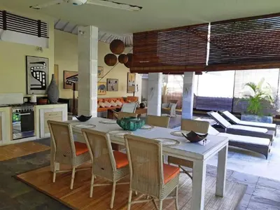 a kitchen and living room with a table and chairs at Villa Sukapadi in Seminyak