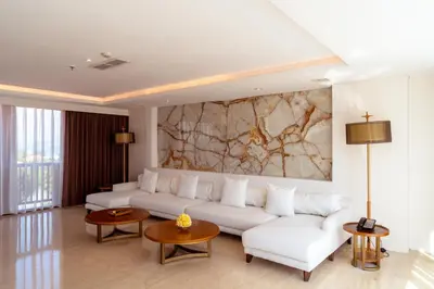 a living room with a white couch and a marble wall at Royal Suites at The Bandha in Legian