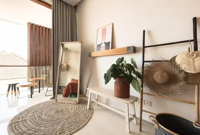 a living room with a potted plant and a mirror at Pelangi 148 Beach Suites in Seminyak