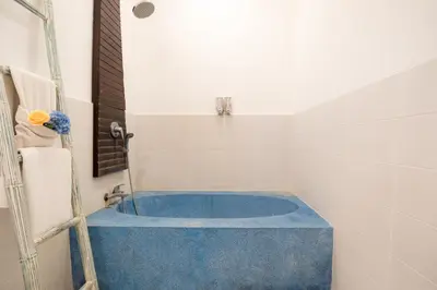 a bathroom with a blue tub in a room at Villa Star in Seminyak