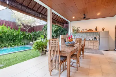 an open kitchen and dining room with a table and chairs at Villa Star in Seminyak