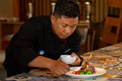 a man sitting at a table with a plate of food at PrimeBiz Hotel Kuta in Kuta