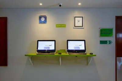 two laptops sitting on a shelf on a wall at PrimeBiz Hotel Kuta in Kuta