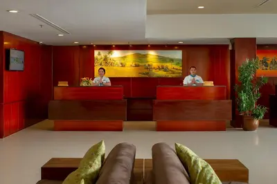 two people sitting at the reception desks in a hotel lobby at PrimeBiz Hotel Kuta in Kuta