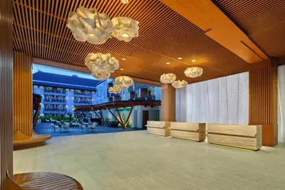 a lobby with benches and chandeliers in a building at Fairfield by Marriott Bali Kuta Sunset Road in Kuta