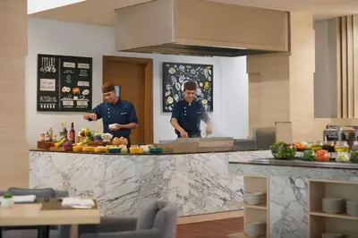 two men standing in a kitchen preparing food at Fairfield by Marriott Bali Kuta Sunset Road in Kuta